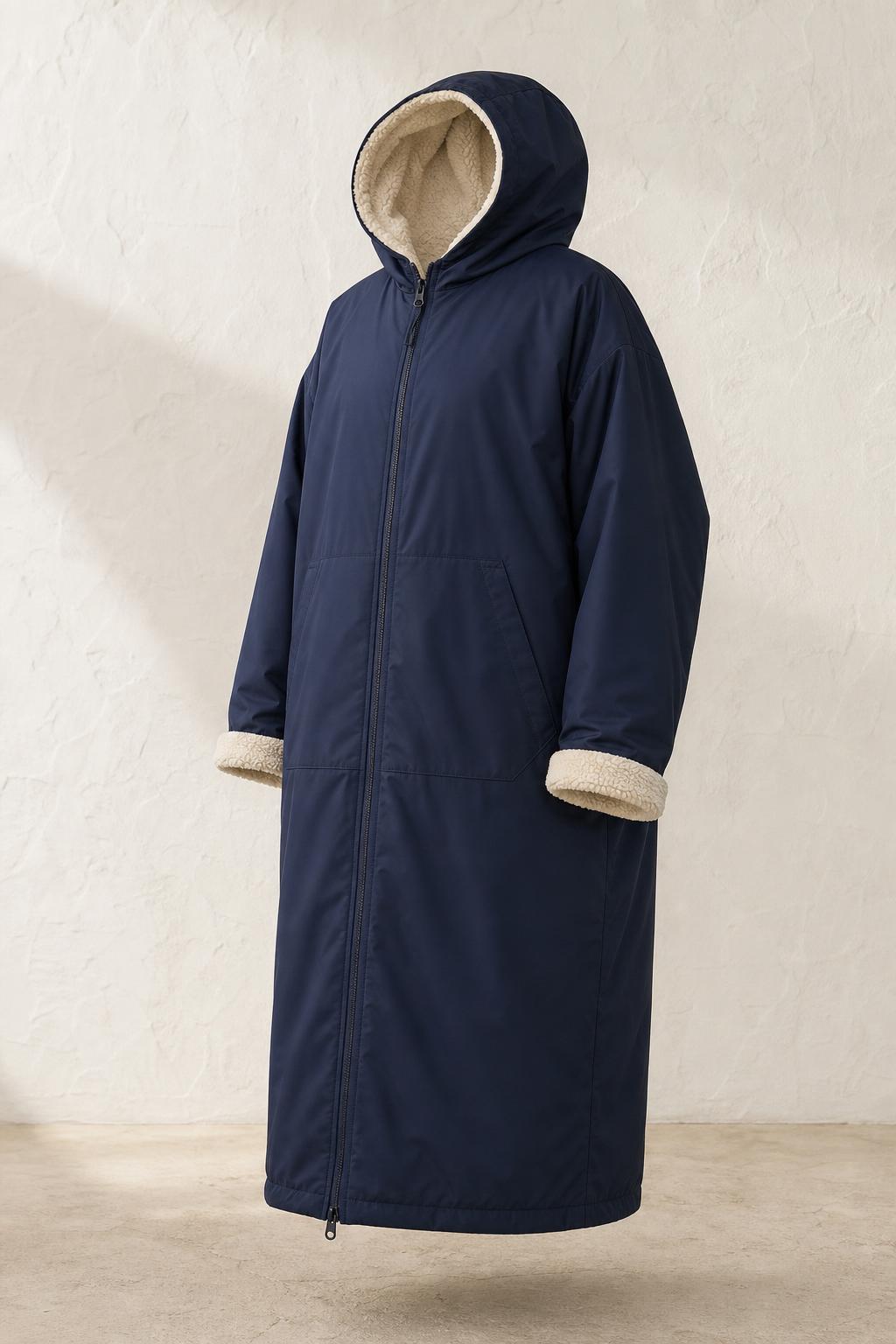 Navy Daybreak changing robe hanging against a weathered beach hut